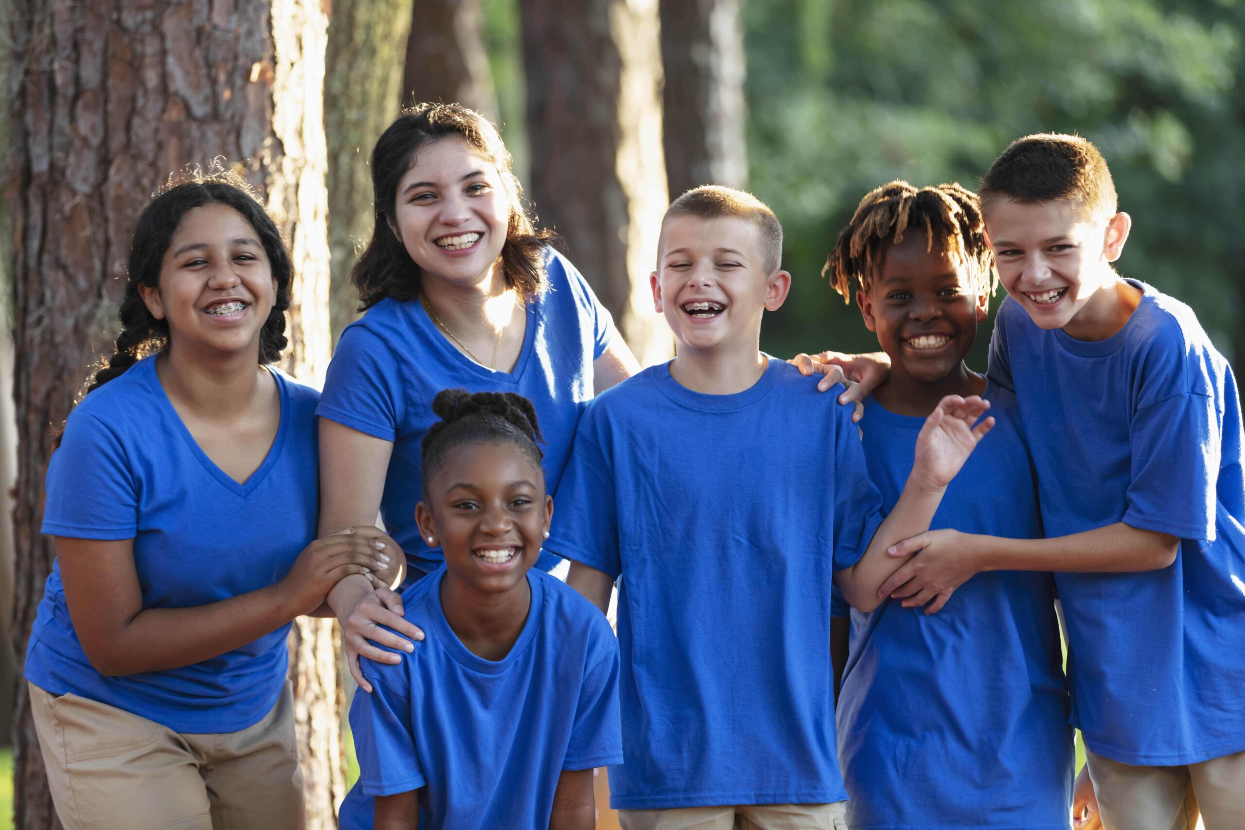 Kids in blue shirt posing for photo.